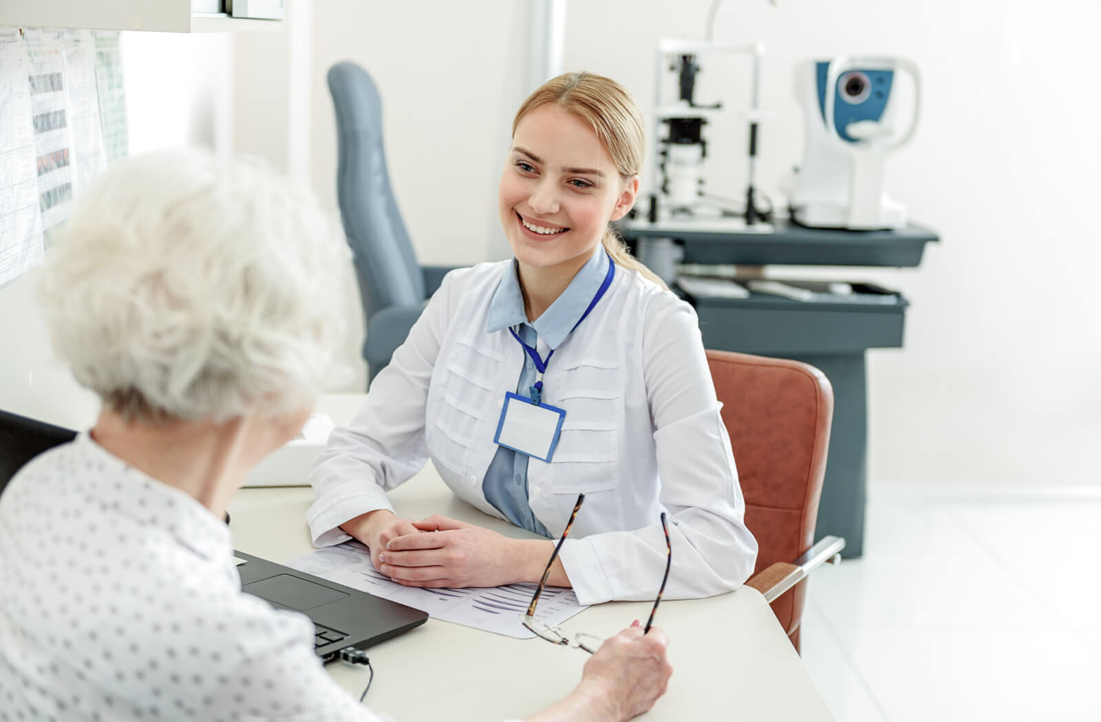 A happy optometrist attentively listening to her senior patient