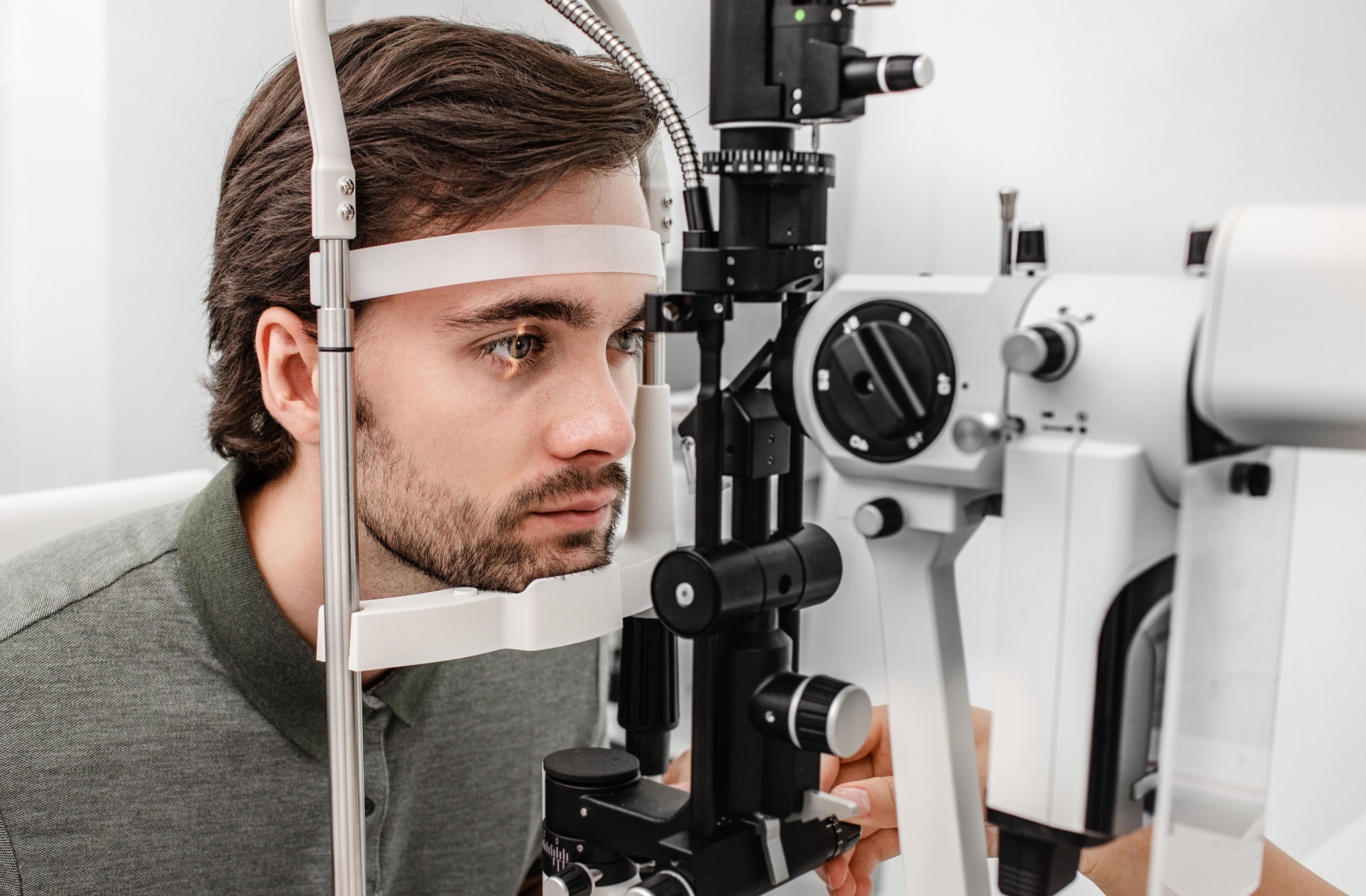 A young man undergoing a slit lamp examination as a part of his regular eye check-ups.
