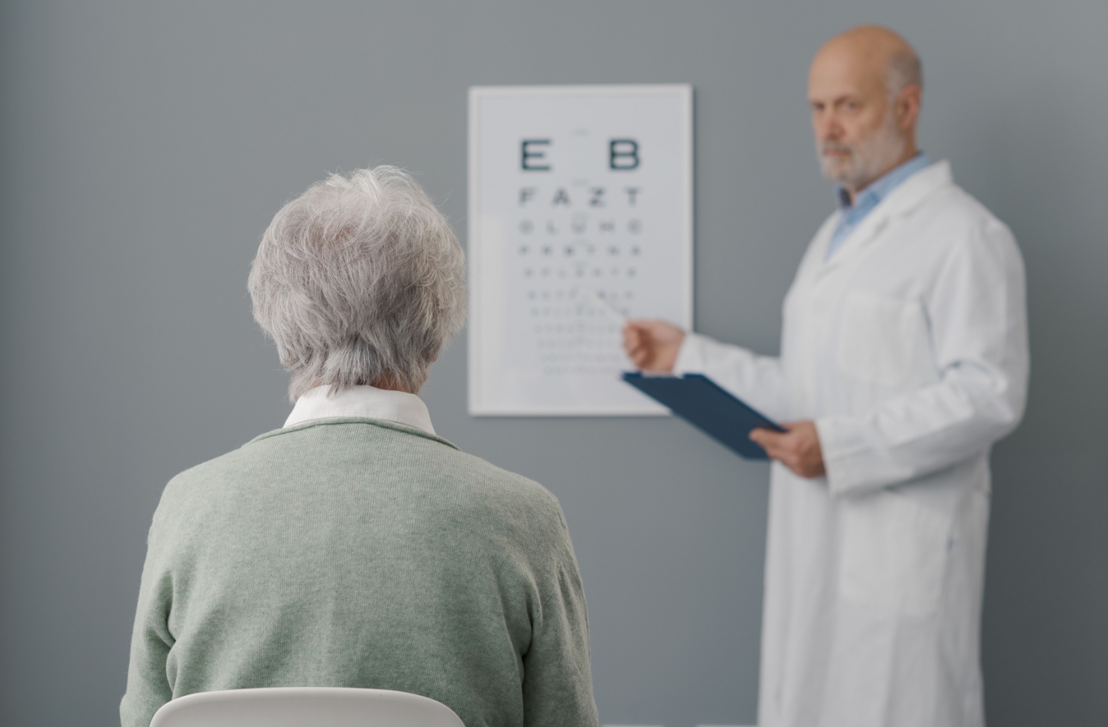 Using a Snellen chart, a mature patient's visual acuity is measured by their optometrist during their routine eye exam.