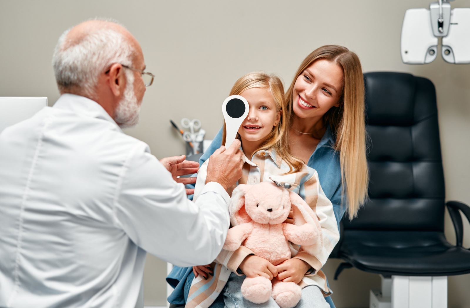 An optometrist evaluates a young child's visual acuity during their routine eye exam.