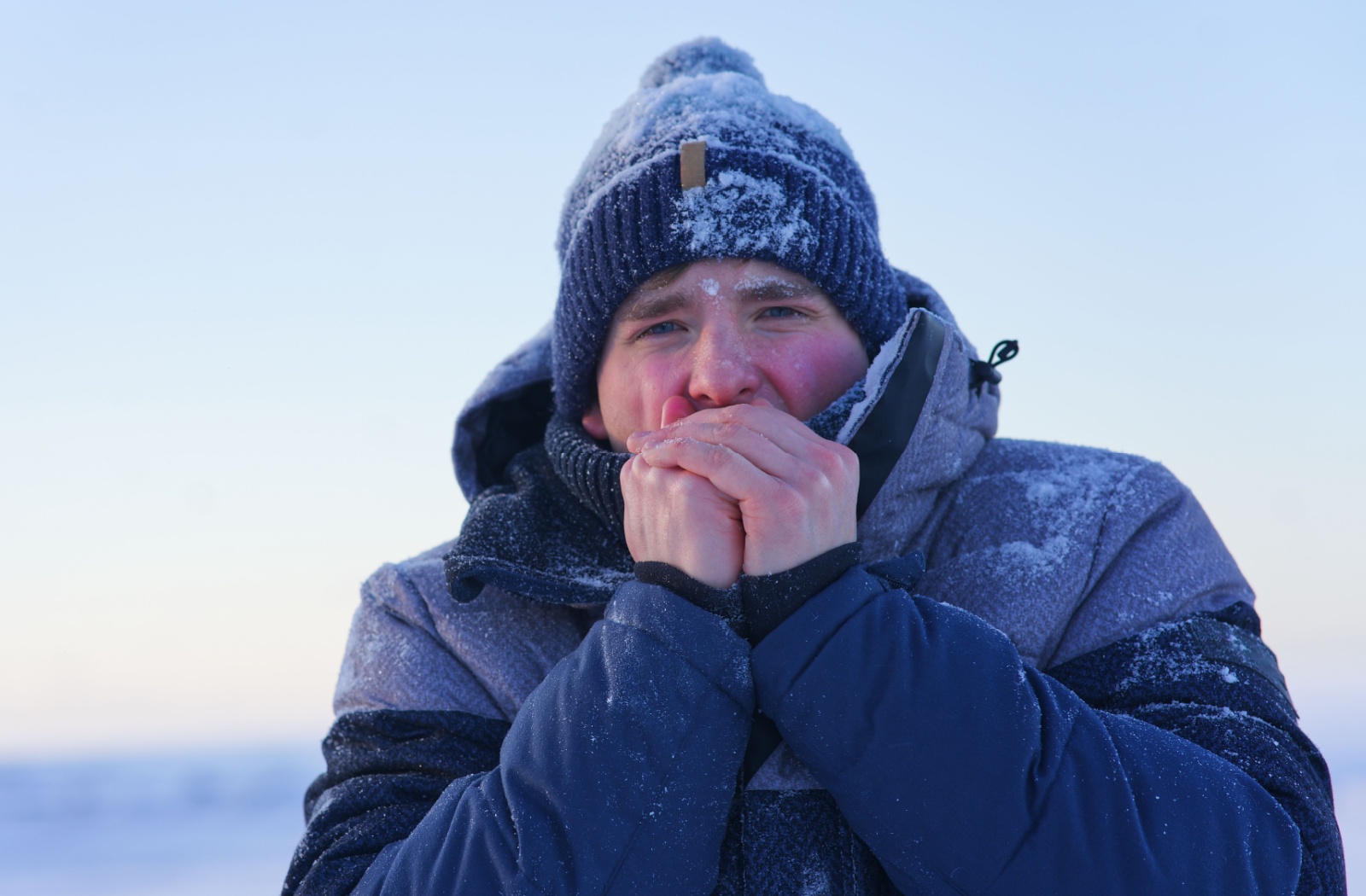 A Calgarian standing outside in snowy cold weather with irritated dry eyes