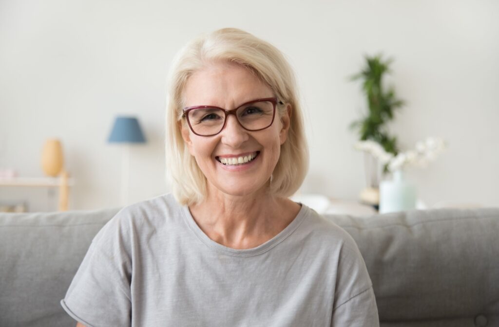 Smiling woman wearing progressive glasses at home.