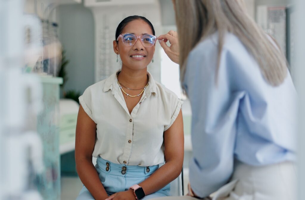 Optometry patient trying on glasses with assistance to correct a refractive error like myopia or astigmatism.