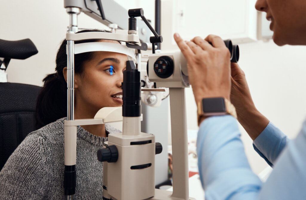 Person sits in an eye exam chair during a slit lamp eye test