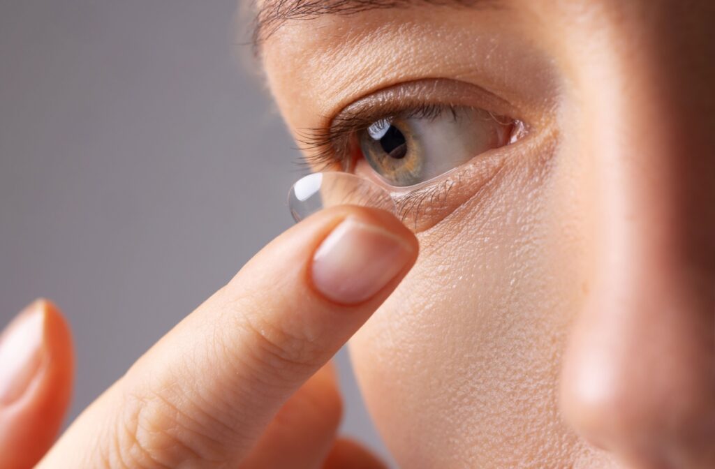 A close up of someone putting a contact lens into their eye